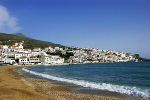 Syros Coastal Village and Sandy Beach Greece A beautiful traditional seaside village in the Cyclades with whitewashed houses stretching along a golden sand beach.